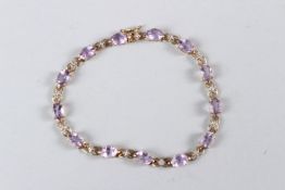 A 9CT YELLOW GOLD AMETHYST BRACELET.