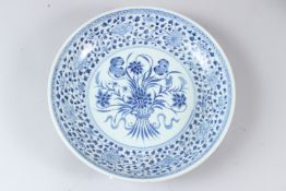 A CHINESE BLUE AND WHITE CIRCULAR DISH, painted to the centre with a floral spray within a floral