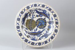 AN OTTOMAN TURKISH IZNIK POTTERY DISH, painted in blue and grey with stylised flowers. 36cms