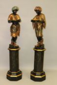 A GOOD PAIR OF CARVED WOOD, POLYCHROME DECORATED AND PARCEL GILDED BLACKAMOORS ON OCTAGONAL PEDESTAL