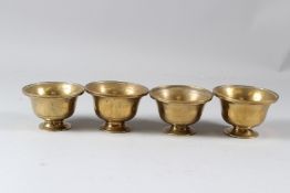 A GROUP OF FOUR 19TH CENTURY INDIAN BRASS CIRCULAR PEDESTAL BOWLS. 10cms diameter.