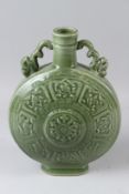 A LARGE CHINESE CELADON GLAZED MOON FLASK, with stylised moulded decoration. 33cms high.