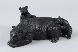 A BRONZE MODEL OF A RECUMBENT BEAR AND TWO PLAYFUL CUBS. 23cms long.