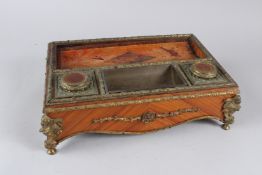 A 19TH CENTURY FRENCH ORMOLU MOUNTED KINGWOOD DESK STAND, with a pair of covered inkwells (lacking