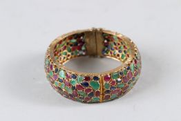 A HIGH CARAT GOLD, RUBY, SAPPHIRE AND EMERALD BANGLE.