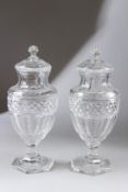 A PAIR OF CUT GLASS PEDESTAL VASES AND COVERS. 31cms high.