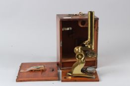 AN EARLY 20TH CENTURY BRASS MICROSCOPE, in a mahogany case.