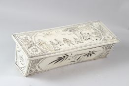 A CHINESE POTTERY PILLOW, painted with figures in a landscape. 45cms long.