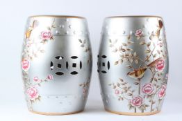 A PAIR OF CHINESE STYLE PORCELAIN BARREL SEATS, silver ground, decorated with birds and flowers.