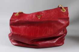 PRADA, A LADIES RED LEATHER HANDBAG with dust bag and certificate.