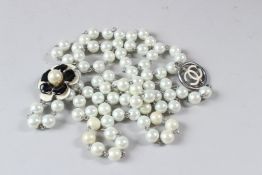 A CHANEL NECKLACE, the pearl with enamel flowerhead pendant.