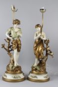 A PAIR OF LARGE, DECORATIVE TABLE LAMPS, modelled as a boy and girl, each holding a rose. 80cms high