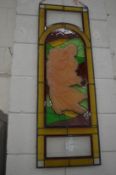 A leaded light panel inset with stained glass and a figural decoration.