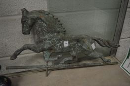 A patinated copper weather vane depicting a horse.