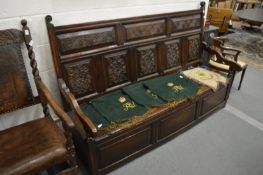 An 18/19th century large oak settle with carved back panel.