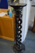 A black marble circular pedestal support with pierced barley twist style column.
