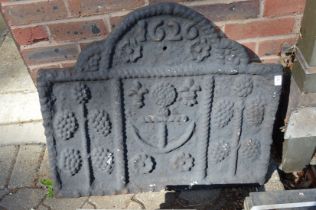 A cast iron fireback decorated with an anchor.
