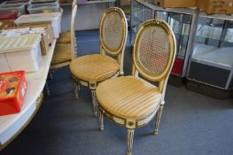 A set of ten painted dining chairs with cane work back panels and upholstered seats.