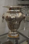 A large plated vase or wine cooler with lion mask ring handles.