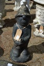 A reconstituted stone garden fountain modelled as a fireman.