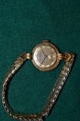 A ladies 18ct gold cased wristwatch with gold plated strap.