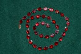 A gold and gem set necklace, possibly garnets.