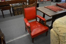 A pair of Arts and Crafts oak armchairs with red leather cloth upholstery together with a similar