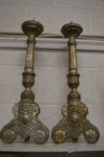 A large pair of white metal overlaid pricket style altar candlesticks.