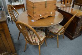 An Ercol drop-flap dining table with four chairs.