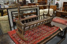 A 19th century Islamic hard wood cradle with mother of pearl inlay and turned decoration.