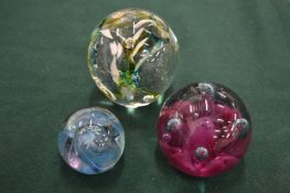 Three glass paperweights.