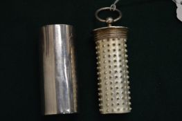 An unusual silver plated cylindrical container housing a nutmeg grater.