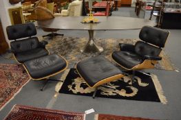 Charles and Ray Eames, a pair of contemporary black leather upholstered armchairs with swivel