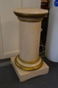 A cream and gilt painted circular wooden pedestal.