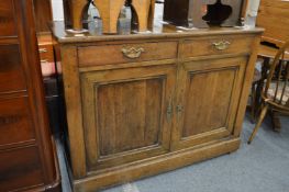 An 18th century Continental oak sideboard with two drawers above two cupboard doors.