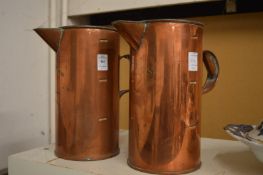 A pair of copper Horlicks jugs.