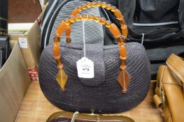A ladies handbag with faux amber handles.