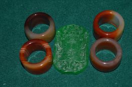 Jade archers rings and a carved jade pendant.