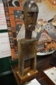 A large carved African wood pulley on later stand.