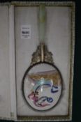 A Chinese porcelain backed hand mirror with jade and white metal handle in a fitted box.