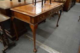 A Georgian style mahogany two drawer writing table on cabriole legs with claw and ball feet.