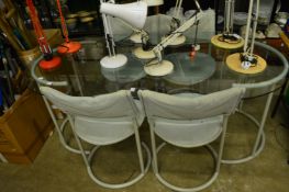 A glass top dining table with four chairs.