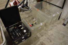 A medical electrical testing device together with a quantity of laboratory glassware.