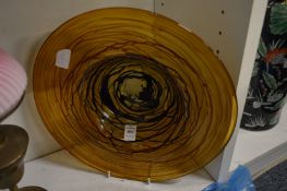 Studio glass circular dish with brown swirled decoration.
