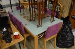 A stylish extending glass dining table and six chairs.