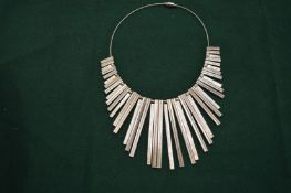 A decorative white metal fringe style necklace.