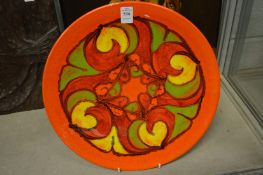 A Poole pottery dish, orange ground with stylised decoration.