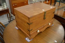 An Eastern teak work box or coffer, the rising top with fitted interior above two small drawers.