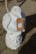 A pair of reconstituted stone garden ornaments or gate post finials modelled as seated birds of