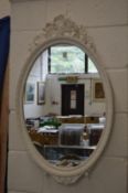Two decorative oval mirrors with white painted frames.